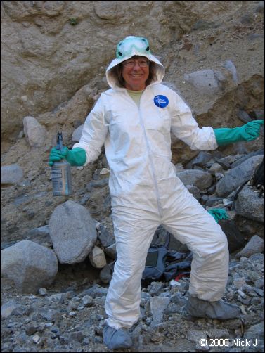 Wearing a white-colored protective suit and hat to apply pesticide